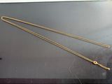 two gold chains are laying on top of a black surface