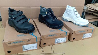 trois paires de chaussures pour enfants dans des boîtes posées sur une table