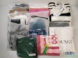 de nombreux types de vêtements différents, rangés dans des sacs posés sur la table