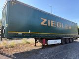 a large green semi truck parked on the side of the road