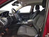 the interior of a red car with a steering wheel and dashboard