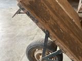 a wooden cart with a metal wheel in a garage