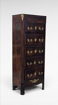 an image of a tall chest of drawers with gold decoration