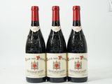 trois bouteilles de vin rouge posées l'une à côté de l'autre sur une surface blanche