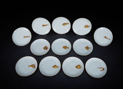 neuf assiettes ornées de poissons rouges sur un fond noir