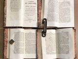 three open books sitting on a table with a key in the middle
