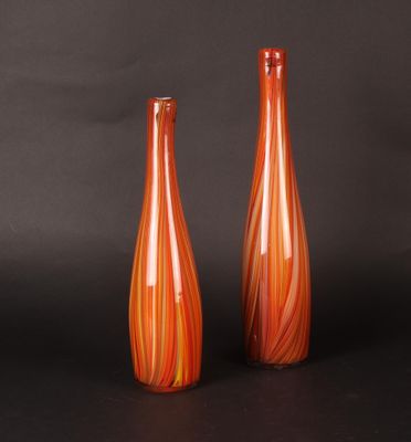 pair of orange glass vases on a black background