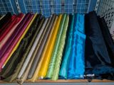 a lot of different colors of fabric on a shelf