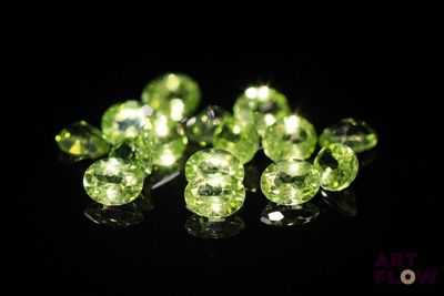 a close up of a bunch of green gems on a black surface
