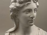 black and white photograph of a statue of a woman with a bird on her head