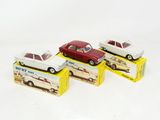three toy cars sitting on top of boxes on a white surface