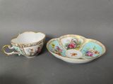 a cup and saucer with a saucer and saucer in the shape of a flower