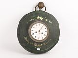 une image représentant une horloge verte accrochée à un mur blanc