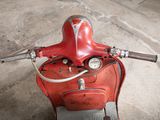 a red scooter that is parked in a garage