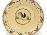une assiette jaune sur laquelle est représenté un coq