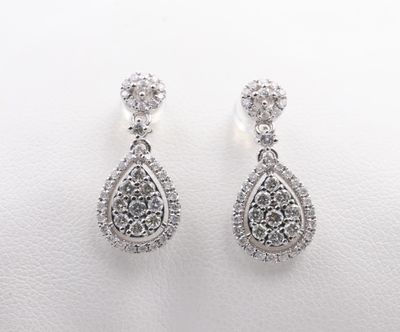 a pair of diamond earrings on a white background