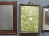 Trois photos encadrées représentant un homme et une femme sont accrochées au mur.