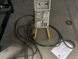 une machine posée par terre à côté d'un enchevêtrement de fils