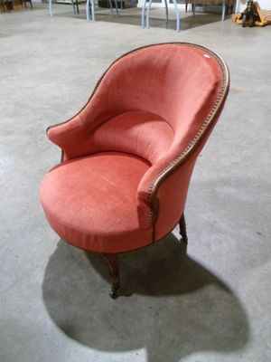 une chaise rose qui se trouve dans une pièce