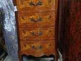 a small chest of drawers with a mirror on top of it