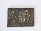 une plaque métallique sur laquelle figurent les portraits d'un homme et d'une femme