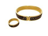 a close up of a gold bracelet and a ring on a white background