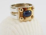 a picture of a gold and silver ring with a blue stone
