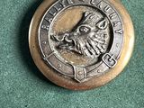 un badge en métal sur lequel est représenté un sanglier