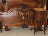 a bed with a wooden headboard and night stand in a room