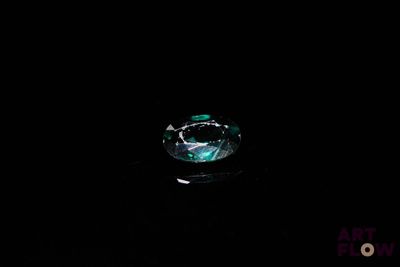 a close up of a ring with a green stone in it