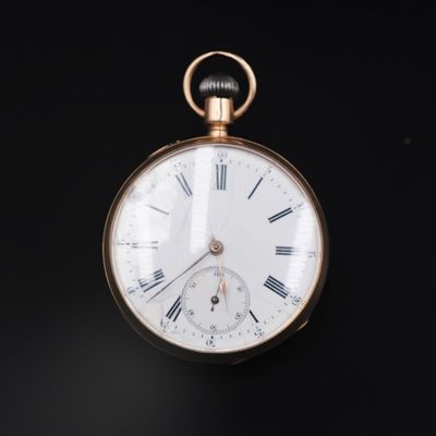 a gold pocket watch with roman numerals on it