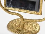 a mirror that is on a stand with a bird on it
