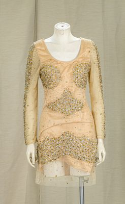 a mannequin dress with sequins and beads on a mannequin stand
