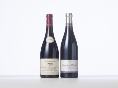 two bottles of wine sitting next to each other on a table