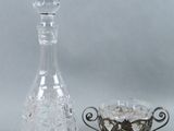 a glass decanter next to a glass bowl on a table