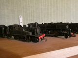 Plusieurs petits trains sont alignés sur une table en bois
