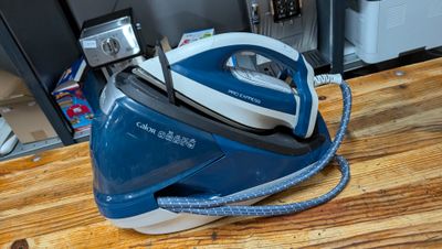 a blue and white steam iron sitting on a wooden table