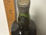 une bouteille d'alcool posée sur une table à côté d'une règle