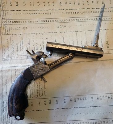 un pistolet posé sur une feuille de papier