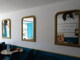 three mirrors on the wall above a table and chairs