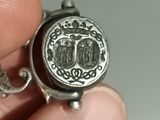someone is holding a silver ring with a picture of a man and a woman on it
