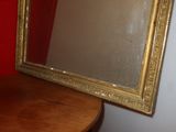 a mirror sitting on a table in front of a red wall