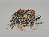 a pile of assorted jewelry on a white surface