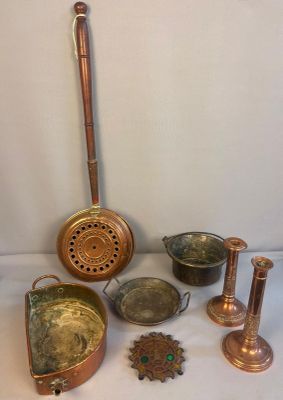 un ensemble d'objets anciens en laiton posés sur une surface blanche