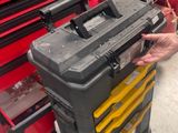 un homme debout à côté d'un chariot à outils sur lequel se trouvent des outils