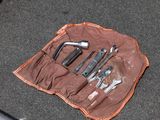 a tool bag with tools in it sitting on the floor