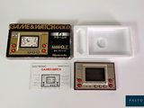 a game and watch set up on a white table