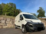 the white van is parked in front of a stone wall