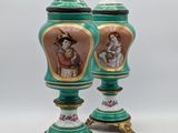 pair of green and gold vases with figures painted on them