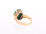 a close up of a gold ring with a green stone
